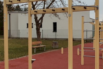 Powiększ obraz: fot. Krzysztof Kozań. Na zdjęciu drążki do podciągania, podesty do stania, obok ławka, z tyłu budynek