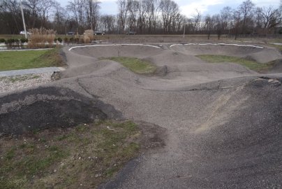 Powiększ obraz: Na zdjęciu znajduje się tor rowerowy pumptrack w Wieliszewie, z tyłu jadą samochody