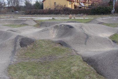 Powiększ obraz: Na zdjęciu widać tor rowerowy pumptrack w Wieliszewie, a w tle zabudowania mieszkalne
