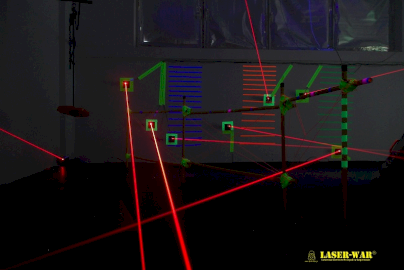 Powiększ obraz: fot. https://www.laser-war.pl/jsp/main.jsf. Na zdjęciu labirynt laserowy z czerwonymi wiązkami świetlnymi