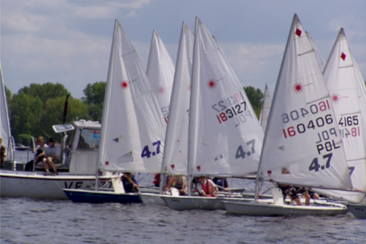 Powiększ obraz: fot. Ośrodek MOS-2, filia w Zegrzu Południowym. Na zdjęciu grupa małych jachtów regatowych z podniesionymi żaglami, biorących udział w szkoleniu lub regatach na otwartym akwenie