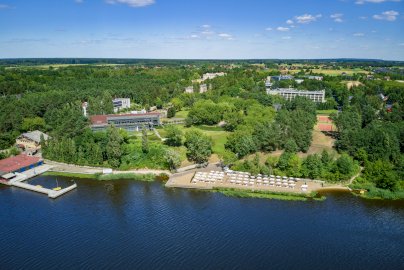 Powiększ obraz: fot. Materiały własne Hotelu Warszawianka. Na zdjęciu hotel Warszawianka z lotu ptaka, z prywatną plażą, przystanią oraz otaczającymi go terenami zielonymi